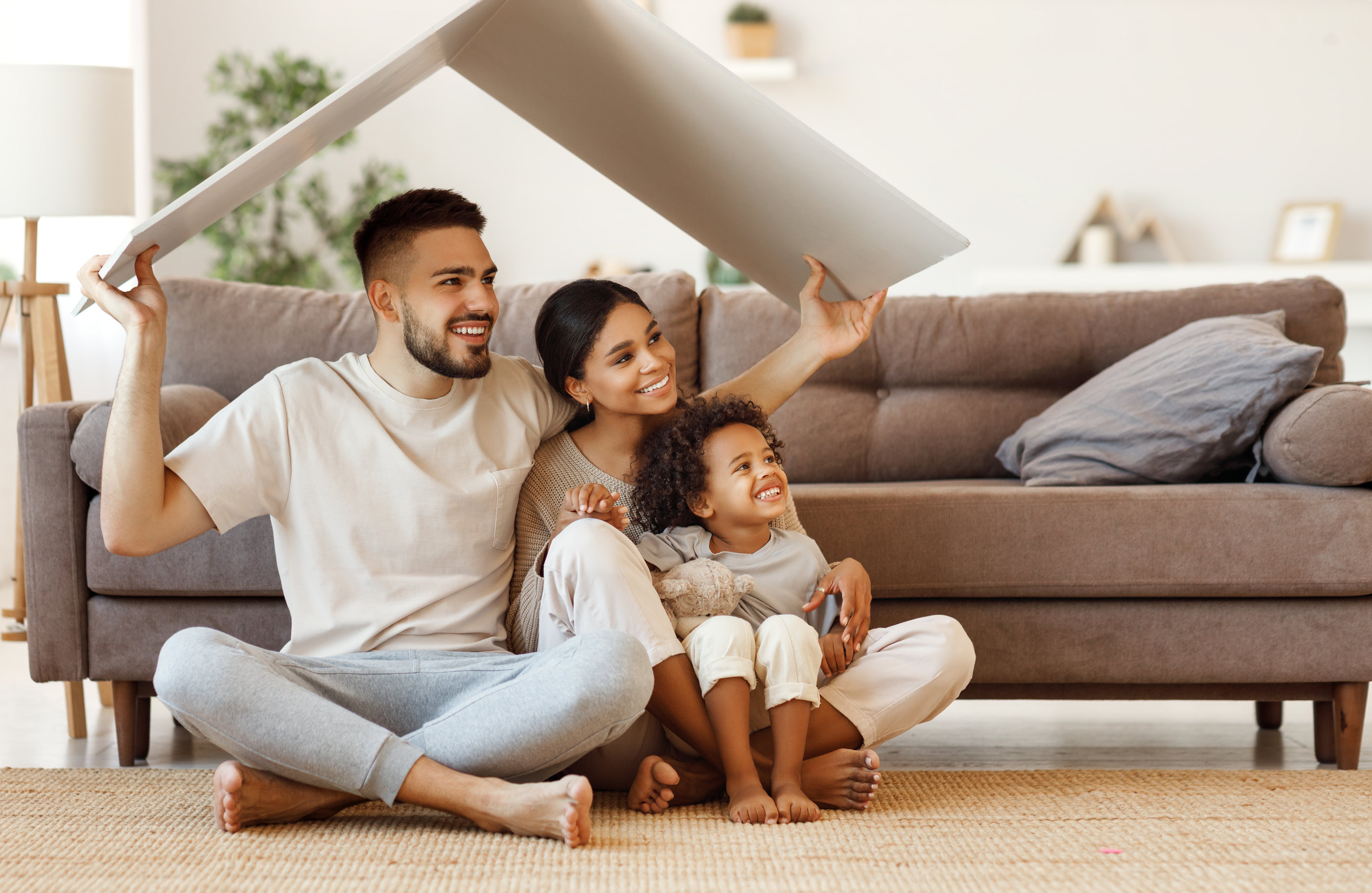 Happy multiethnic family under fake roof in living room
